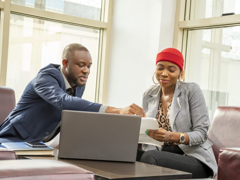A young black businessman and woman going through some paperwork together